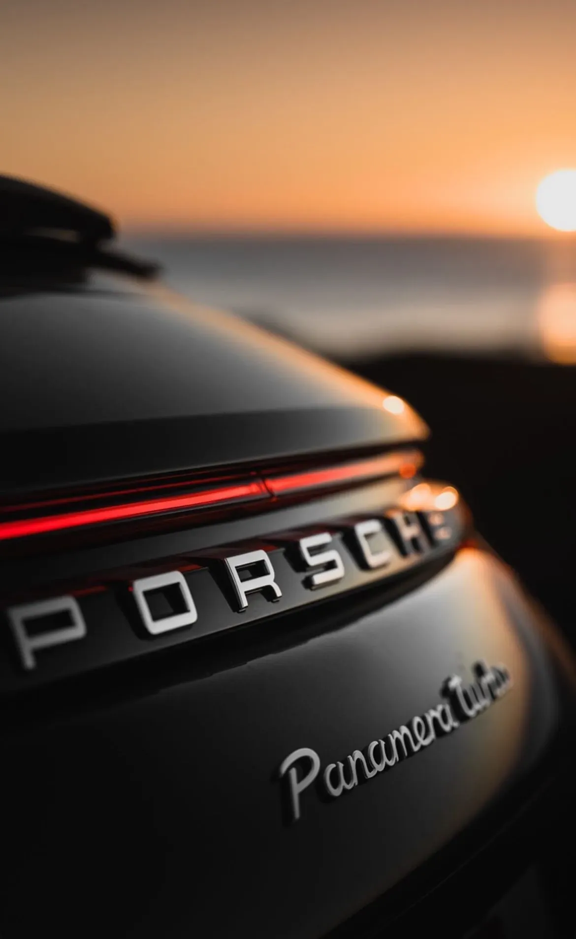 Porsche Panamera Turbo rear badge and taillight at sunset